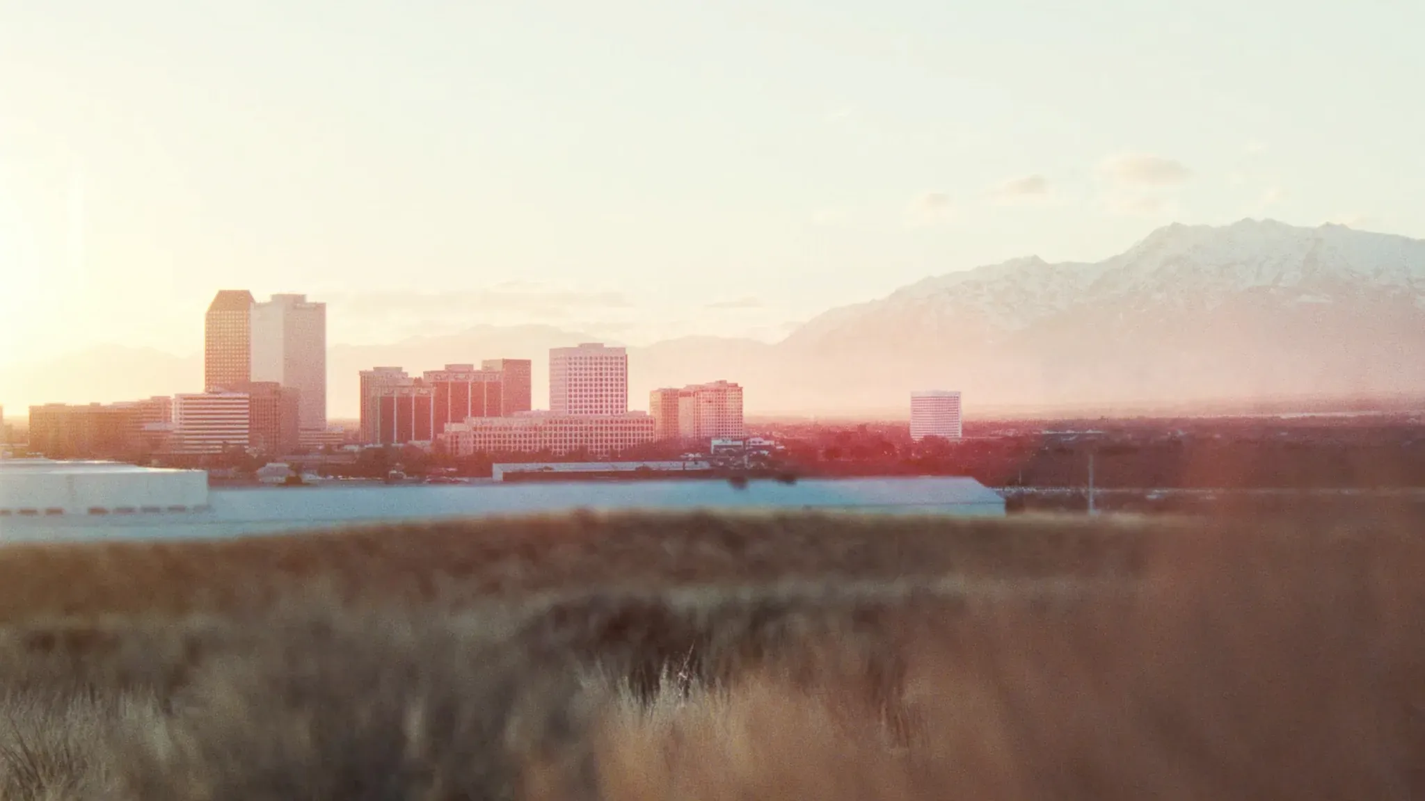 Downtown Salt Lake City skyline with Wasatch mountains beyond at late afternoon.